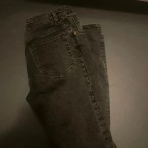 Svarta jeans från MONKI - Säljer ett par svarta jeans från MONKI i bra skick. De har en klassisk femficksdesign med dragkedja och knapp framtill. Perfekta för både vardag och fest! 🖤