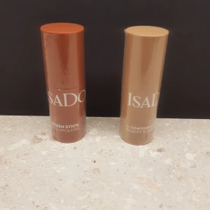 Blush och Contour Stick från IsaDora - Säljer två smidiga stickprodukter från IsaDora. Den ena är en blush stick i en varm, rödbrun nyans perfekt för både läppar och kinder. Den andra är en contour stick i en naturlig beige ton för att skulptera och definiera ansiktet. Perfekta för en snabb och enkel sminkrutin! 85kr/st