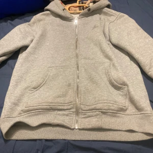 Grå hoodie från Burberry - Säljer en snygg grå hoodie från Burberry i mycket bra skick. Den har en dragkedja framtill och klassiskt rutigt mönster på insidan av luvan. Perfekt för höst och vår, och den är supermjuk och bekväm. Passar både till vardags och lite mer uppklädda tillfällen. Jag tar även emot byten helst vinter jackor eller nått annat. Den sägs att det är storlek M men passar också S.