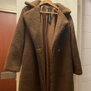 Brun teddyjacka - Säljer en supermysig brun teddyjacka. Perfekt för kalla dagar med sitt fluffiga material. Den är i helt nytt skick med lappar kvar