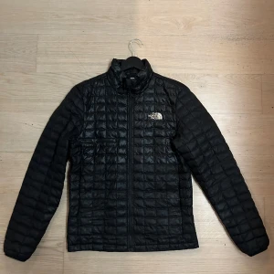 Svart pufferjacka från The North Face - Säljer en svart pufferjacka från The North Face i mycket bra skick. Jackan har en quiltad design med dragkedja framtill och är perfekt för kyliga dagar. Den är långärmad och passar både höst och vinter. Perfekt för dig som vill hålla stilen samtidigt som du håller värmen!