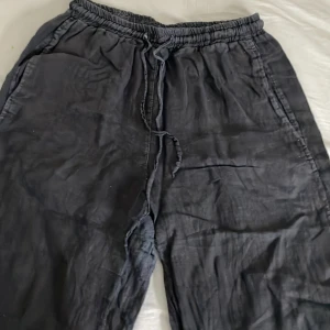 Svarta washed linnebyxor med snörning - Säljer ett par svarta washed linnebyxor i bra skick. Endast använda få gånger. De har en bekväm passform och är lagom i längden till mig som är 1,60 lång. Byxorna har en elastisk midja med snörning. De är i 36/38. De är köpa i Göteborg för 600 kr men klippt bort lappen i byxorna då den skavde, och kommer tyvärr inte ihåg märket! Ni är så välkomna att ställa frågor eller om mer bilder!