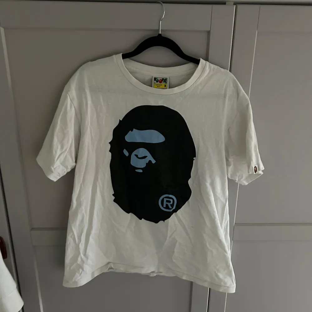 Säljer en bape tshirt i storlek M. T-shirten är kortärmad och har en avslappnad passform. Perfekt för vardagsbruk eller som statement-plagg. Den är i bra skick men lite skrynklig men inget som inte försvinner i tvätten! Kan absolut ta byten!. T-paidat.
