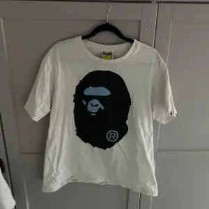 Säljer en bape tshirt i storlek M. T-shirten är kortärmad och har en avslappnad passform. Perfekt för vardagsbruk eller som statement-plagg. Den är i bra skick men lite skrynklig men inget som inte försvinner i tvätten! Kan absolut ta byten!