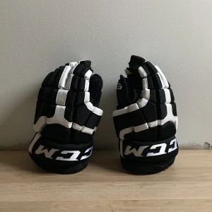 Svarta och vita hockeyhandskar från CCM - Säljer ett par svarta och vita hockeyhandskar från CCM, modell C300. Storlek 13/33 cm. Har extra bra grepp i handflatorna. Pris kan diskuteras!
