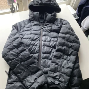 Peak performance jacka barn 160 - En använd peak jacka med en lagning bak på jackan och ett litet hål på armen