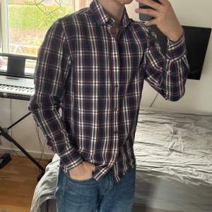 Säljer en vintage flanellskjorta från Levi Strauss & Co i storlek S. Skjortan har en snygg kombination av blått, rött och vitt med långa ärmar och knappar framtill. Perfekt för både vardag och festliga tillfällen. Passar bra till jeans eller chinos för en avslappnad stil.