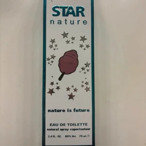 Star Nature Eau de Toilette - Säljer en flaska Star Nature Eau de Toilette med en söt och lekfull design. Förpackningen har en bild av sockervadd omgiven av stjärnor, vilket ger en känsla av nostalgi och glädje. Perfekt för den som älskar unika och roliga dofter. Flaskan innehåller 70 ml och har en alkoholhalt på 80% vol.