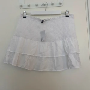 Vit volangkjol - Säljer en superfin vit kortkjol med volanger. Storlek L