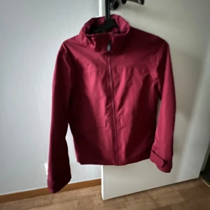 Vinröd jacka med dragkedja - Säljer en snygg vinröd jacka i mycket bra skick. Den har en dragkedja framtill och är perfekt för höst och vår. Jackan har långa ärmar och en stilren design som passar till det mesta. Perfekt för dig som vill ha en stilren look!
