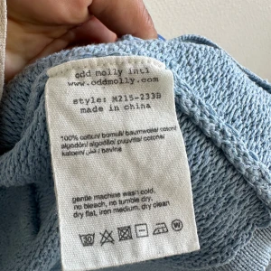 Ljusblå stickad kofta från Odd Molly - Säljer en superfin ljusblå stickad kofta från Odd Molly. Den är i 100% bomull och har ett snyggt knytband i midjan. Perfekt för vår och sommar! Koftan har långa ärmar och en avslappnad passform. Den är i mycket bra skick och redo för nya äventyr. 🌟