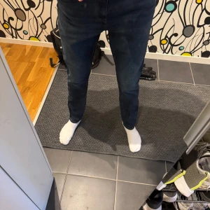 Mörkblå jeans från Uniqlo - Säljer ett par mörkblå jeans från Uniqlo i bra skick. De är tillverkade i bomull med en liten del elastan för extra komfort. Perfekta för både vardag och fest! 🕺