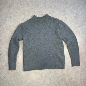 Grå stickad tröja från Zara - Mysig grå stickad tröja näst in till onanvänd. Perfekt för kyliga höst- och vinterdagar. Tröjan har långa ärmar och ribbade muddar vid ärmslut och nederkant. Enkel och stilren design som passar till det mesta.