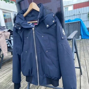 moose knuckles jacka - En riktigt fin, skön och varm vinterjacka som då inte kommer till användning sen den är köpt då den va lite för liten och köpt en annan sen glömt bort denna. Priset är ej hugget i sten 
