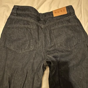 Mörkblå jeans från NA-KD - Säljer ett par snygga mörkblå jeans från NA-KD. De har en klassisk design med raka ben och medelhög midja. Oanvända. Storlek 36
