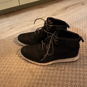 Svarta boots från Timberland - Säljer ett par svarta boots från Timberland i storlek 40. De är i bra skick med snygg snörning och en robust sula som ger bra grepp. Perfekta för höst och vinter, och de funkar lika bra till vardags som till lite mer uppklädda tillfällen.
