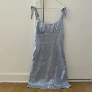 Satin ljusblå klänning med mönster - Den har typ en slags cheeta mönster som syns ganska väl! Jätte fin och perfekt för alla årstider❤️Har aldrig använt! Passar S-M Skriv för mått eller frågor, Priset går att diskutera!🙏 snälla köp