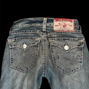 True religon bootcut jeans - Jätte snygga true religion jeans som går att styla med typ allting. mycket hål i de men det syns inte så mycket när man har på sig de. god skick förutom hålen. Innerbenslängd: 81cm  midjemått 78cm Kontakta mig🫶🏼