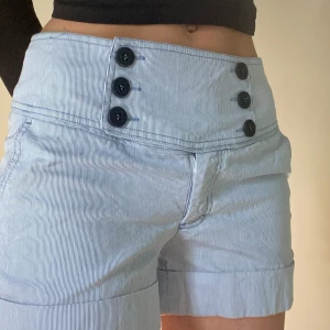 Lågmidjade tygshorts - Mått: Midja tvärs över: 41 cm  Innerbenslängd: 8 cm  Benöppning: 28 cm