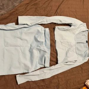 Ljusblå ribbad långärmad topp med kjol💕 - Snygg ljusblå ribbad topp med långa ärmar och rund hals. Perfekt för en stilren och bekväm look. Passar bra till både jeans och kjol.