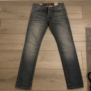 Jack & Jones slim fit jeans - Snygga blå slim fit jeans med en klassisk femficksdesign. Jeansen har en lätt tvättad look och är perfekta för en stilren vardagsoutfit. Modellen heter 'Glenn' och har en smal passform som sitter snyggt på benen.