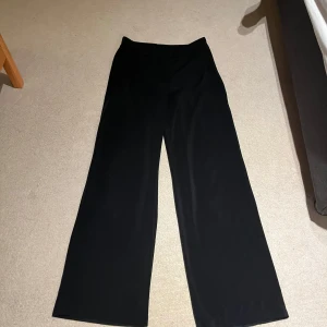 Svarta vida byxor - Snygga svarta byxor med hög midja och vid passform. Perfekta för en stilren look.