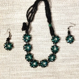 Handgjord Grönt pärlset med halsband och örhängen - Handgjord Unikt set med ett halsband och matchande örhängen i gröna och svarta pärlor. Halsbandet har en rad av gröna pärlor omgivna av mindre svarta pärlor, och örhängena har en liknande design. Perfekt för att ge en färgklick till din outfit.