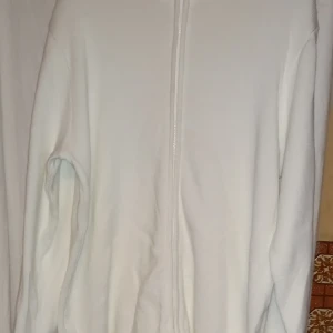 Vit tröja med dragkedja från Lindex - Säljer en stilren vit tröja från Lindex med dragkedja framtill. Perfekt för en avslappnad look. Tröjan har långa ärmar och är i en mjuk och bekväm kvalitet.