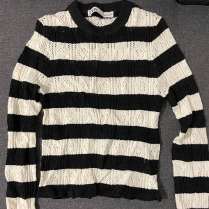 Randig stickad tröja från Zara - Snygg svartvit randig stickad tröja från Zara. Perfekt för kyligare dagar med sin mysiga och stilrena design. Tröjan har långa ärmar och en rund halsringning.