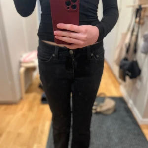 Svarta jeans från Levi's - Säljer ett par svarta Levi's jeans i modellen Superlow Boot. De har en låg midja och en bootcut-stil som ger en snygg siluett. Perfekta för en avslappnad look. Storlek W25. Dom har blivit använda 2-5 ggr 