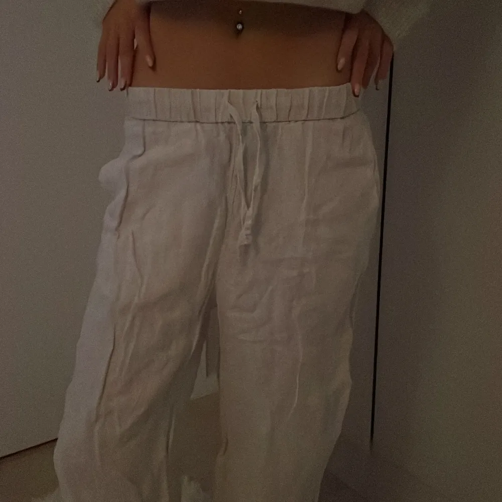 Snygga vita/begia linnebyxor med loose fit och dragsko i midjan. Perfekta för en avslappnad stil. Byxorna har en bekväm passform och är tillverkade i ett lätt och luftigt material.. Farkut & Housut.