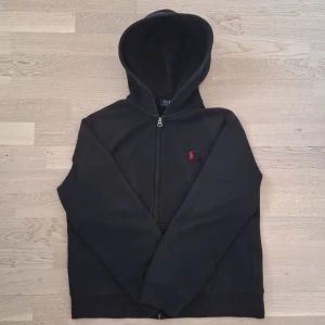 Svart hoodie från Ralph Lauren - Säljer en Ralph Lauren zip hoodie I storleken XS. Den är i jättebra skick, bara använd fåtal gånger. Skicka gärna meddelande om du är intresserad, priset går att diskuteras.