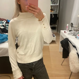 Stickad tröja - Jättefin stickad polotröja från holly & white, tyvärr klippt bort storlekslappen men skulle säga att den är en storlek s! Krämvit med guldiga knappar! Lite skrynklig då den legat ihopvikt