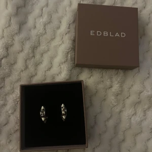 Edblad tagg örhängen - Säljer dessa skit snygga örhängen från Edblad med nitar på, Nästan helt oanvända och säljer pågrund av att jag inte använder silver smycken! Lådan ingår och resten som kom med, Hör av dig vid frågor!❤️‍🔥❤️‍🔥