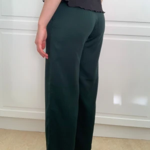 Mörkgröna byxor - Säljer ett par mörkgröna byxor i loose fit. Perfekta för en avslappnad stil, till hösten och våren. De har en enkel design utan mönster eller detaljer, vilket gör dem lätta att matcha med olika toppar.