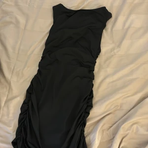 Svart snygg klänning  - Öppen rygg med resår på sidorna. Kort och passar året runt. Passar S -väldigt stretchig