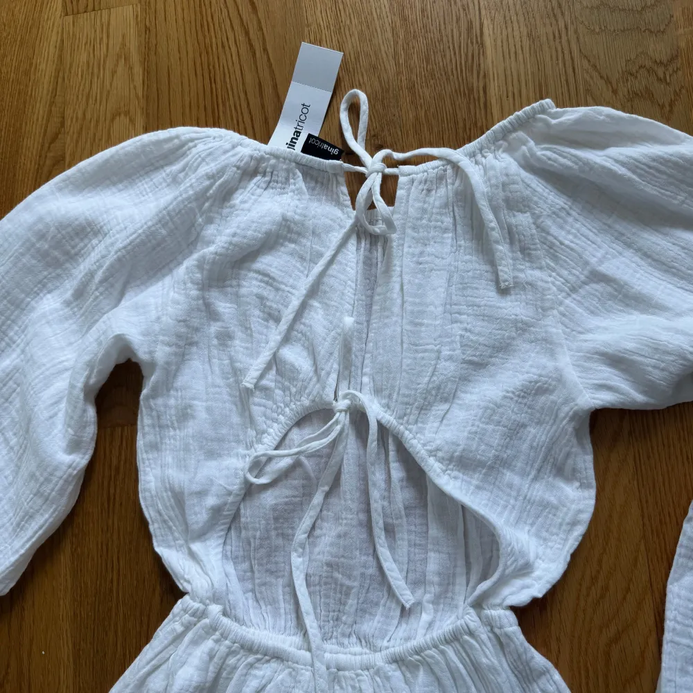 Säljer en superfin vit långklänning från Gina Tricot . Den har långa ärmar och en öppen rygg med knytning, vilket ger en elegant touch. Perfekt för sommarens alla fester eller en mysig midsommar. Klänningen är i ett lätt och luftigt material, vilket gör den bekväm att bära hela dagen.. Klänningar.