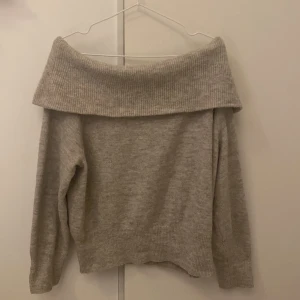 Beige offshoulder tröja - Säljer en superfin beige offshoulder tröja i stickat material. Använt ett fåtal gånger. Perfekt för höst och vår med sin mysiga och stilrena design. Tröjan har långa ärmar och en bred krage som ger en elegant look 💫 skriv för mer bilder💞