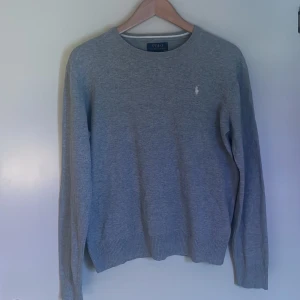 Grå tröja från Polo Ralph Lauren - Säljer en stilren grå tröja från Polo Ralph Lauren i mycket bra skick. Den är tillverkad i mjuk pima bomull och har en broderad logga på bröstet. Perfekt för alla olika årstider, särskilt höst. Passar bra till både vardag och lite finare tillfällen. Sitter bäst på XS men fungerar också som S.