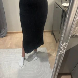 Stickad kjol - Stickad kjol från Gina tricot med slits på sidan.  Storlek M aldrig använd