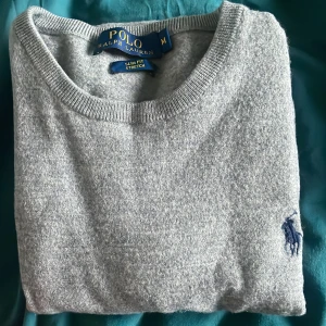 Grå tröja från Ralph Lauren - Säljer en stilren grå tröja från Ralph Lauren. Den är i slim fit och stretchigt material. Ordinarie pris: 2199. Mitt pris 800. Skick 9/10 inga tecken på användning och säljer tröjan på grund av att den har tyvärr blivit för liten på mig