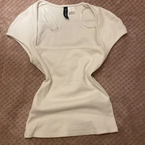 Vit T-shirt  - Jättesöt vit t-shirt😍🎀. Fint skick förutom en pytteliten fläck längst ner (se på bild 2), inget som man tänker på❤️säljer eftersom den inte kommer till användning.💋