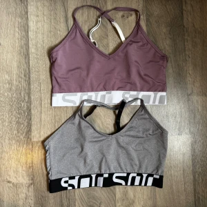 Paket två toppar från Soc - Dessa två toppar ifrån Soc är i använda några få gånger var. En lila och en grå i storlek M. Dom är i träningsmaterial. Säljes tillsammans för 100kr