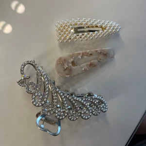 Klämmor & hårspänne - Två klämmor, en stor påfågelliknande klämma i silver och en lite mindre klämma som är beige, rosa för mindre uppsättningar. Också ett litet hårspänne med pärldetaljer🌸💞Inget säljs var för sig utan allt tillsammans!
