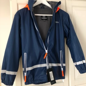 Regnjacka blå Tenson i stl 146/152 - Säljer helt ny regnjacka i stl. 146/152 från Tenson pga fel köp. Passar fint till en kille eller en tjej. 100% vattentät med värmande fleece.