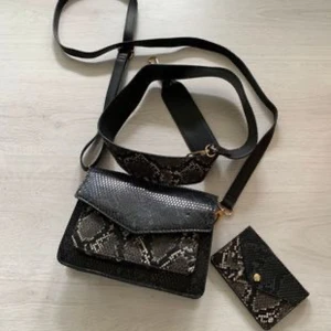 Svart axelväska med ormmönster - Säljer en snygg svart axelväska med coolt ormmönster. 60kr