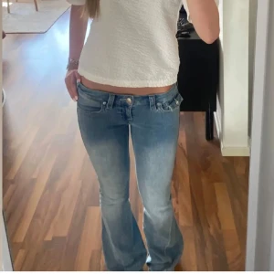 True religion jeans - Lågmidjade bootcut jeans från true religion i jättefint skick. Lånade bilder från säljaren innan som är 168. De är uppsydda där nere men man kan ta ner och då är de lite trasiga längst ner men nog inget man tänker på❤️ annars jättefina MINST 800kr