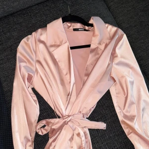 Rosa topp - Fin rosa topp i storlek S. Toppen går att knyta i midjan och banden kan även tas loss om man vill använda den utan.  I nyskick. 