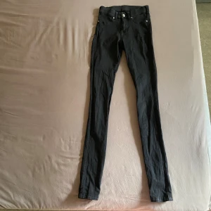 Svarta skinny jeans - Säljer ett par svarta skinny jeans från DR DENIM i storlek xs. De är tighta och har en klassisk femficksdesign med knappar och dragkedja fram. Perfekta för både vardag och fest! I använt skick. 