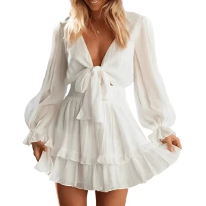 Vit kortklänning med volanger - Supersnygg klänning från Dressy med volanger och knytning framtill. Klänningen har en luftig passform, perfekt för studenten eller en varm sommardag. Den är gjord i ett lätt och bekvämt material. Aldrig använt 💗Nypris 349kr